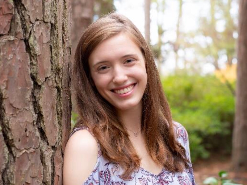 young teen leaning on tree