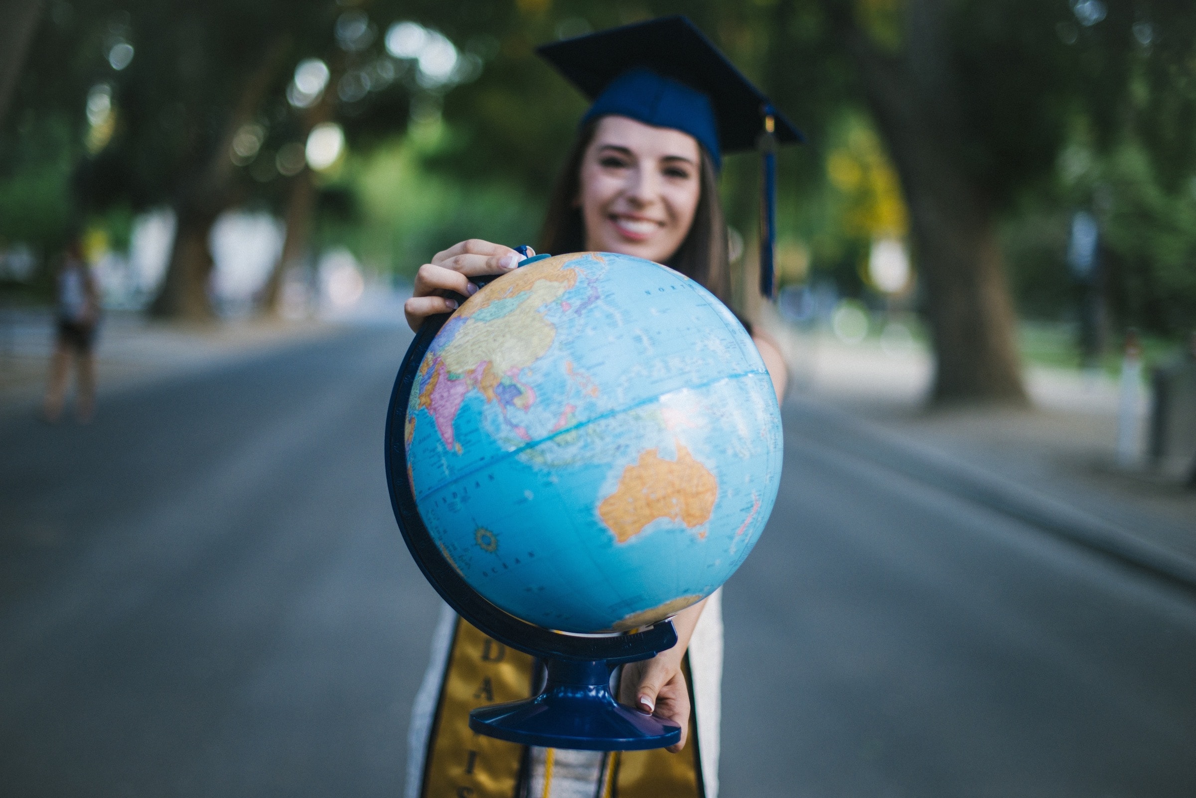 graduate holding world globe